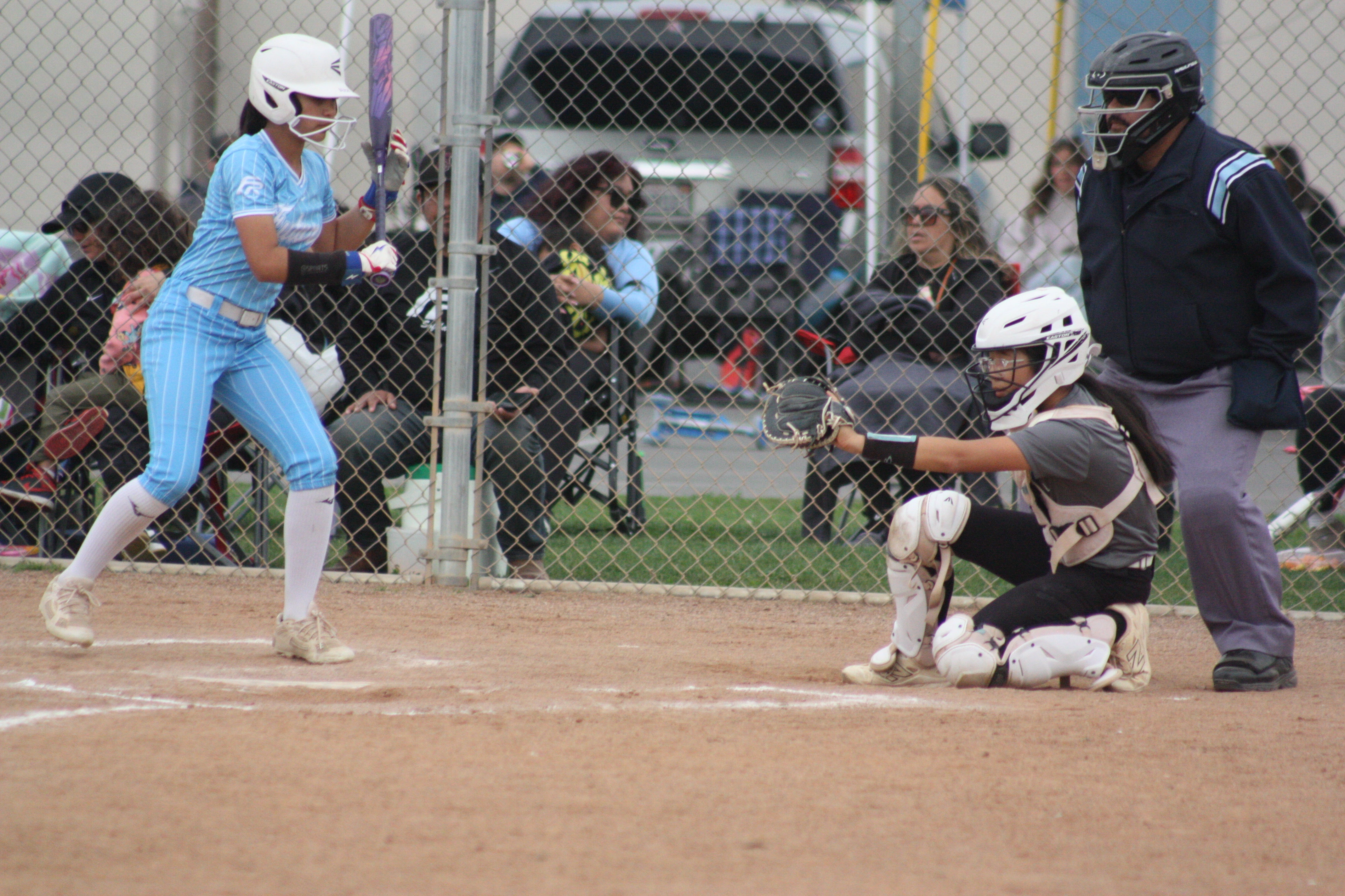 Sophia's daughter crouched behind home plate as catcher during a softball game
